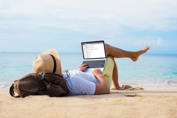 Man reading email on laptop while relaxing on beach Unrecognizable male reading email on laptop while relaxing on beach Digital Freedom stock pictures, royalty-free photos & images